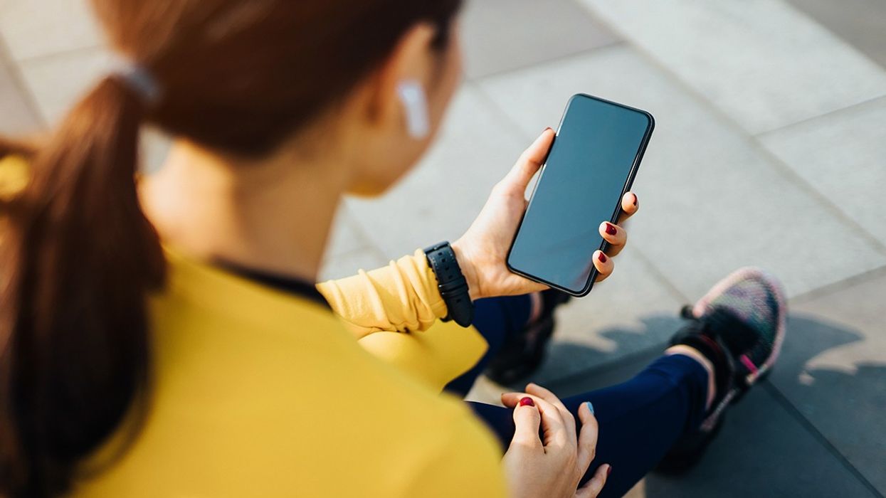 Woman looking down at phone while working out