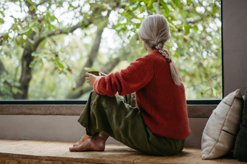 WOMAN LOOKING OUT WINDOW