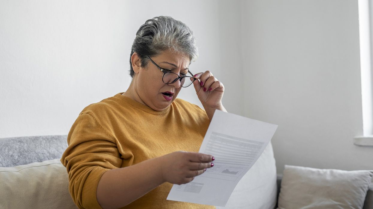 Woman looking shocked at bills
