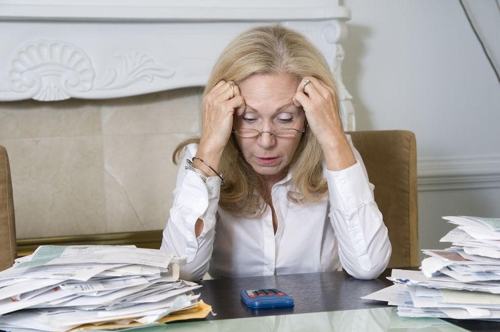Woman looking stressed at calculator