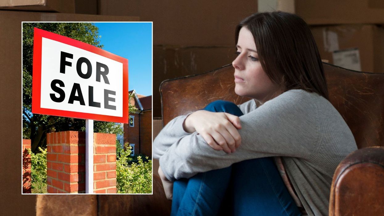 Woman looking worried and for sale sign outside house