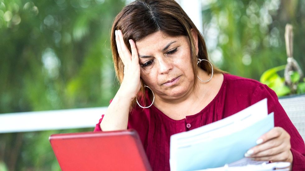 Woman looking worried at documents