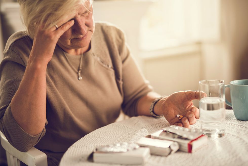 Woman looking worried holding prescriptions
