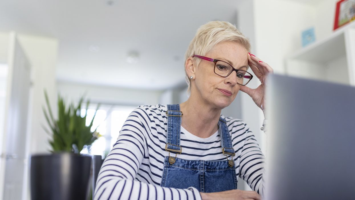 Woman looks worried as she looks at laptop