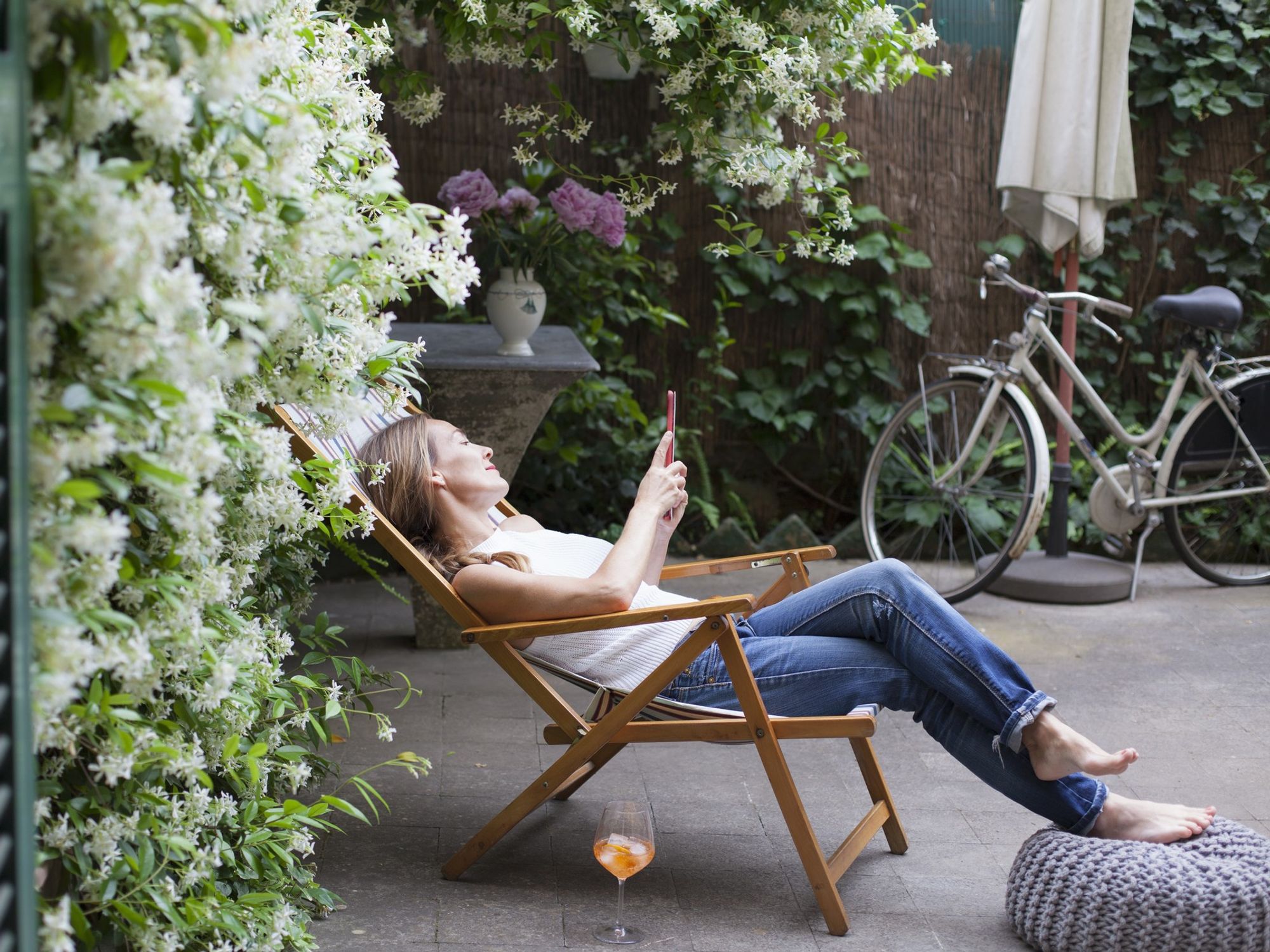 Woman lounging in deck chair in garden