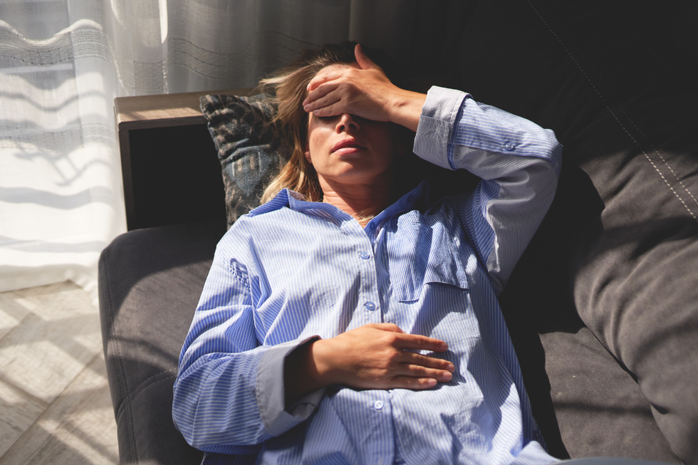 Woman lying down with her hand on her head