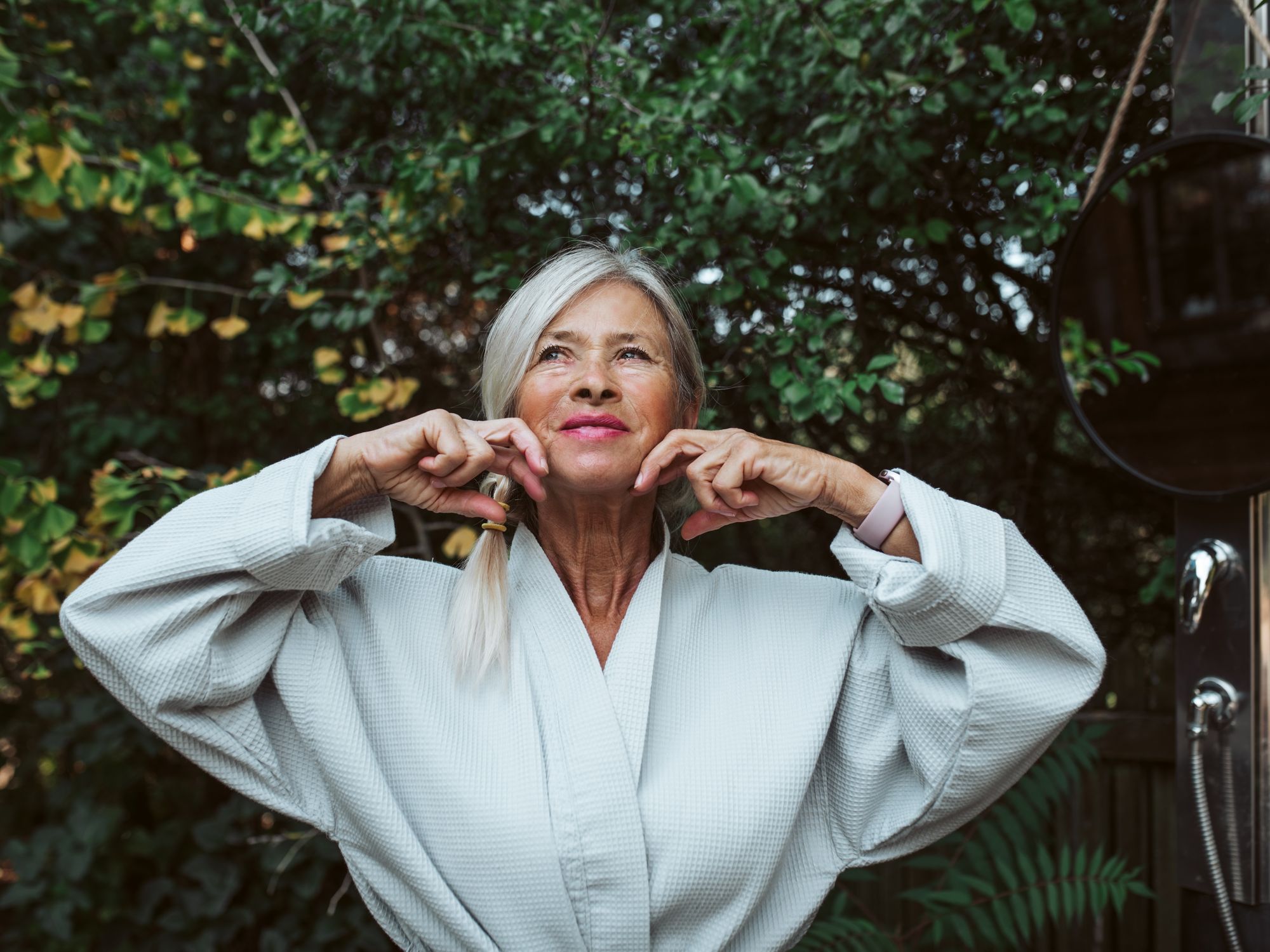 Woman massaging face outdoors