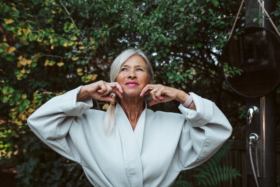 Woman massaging face outdoors