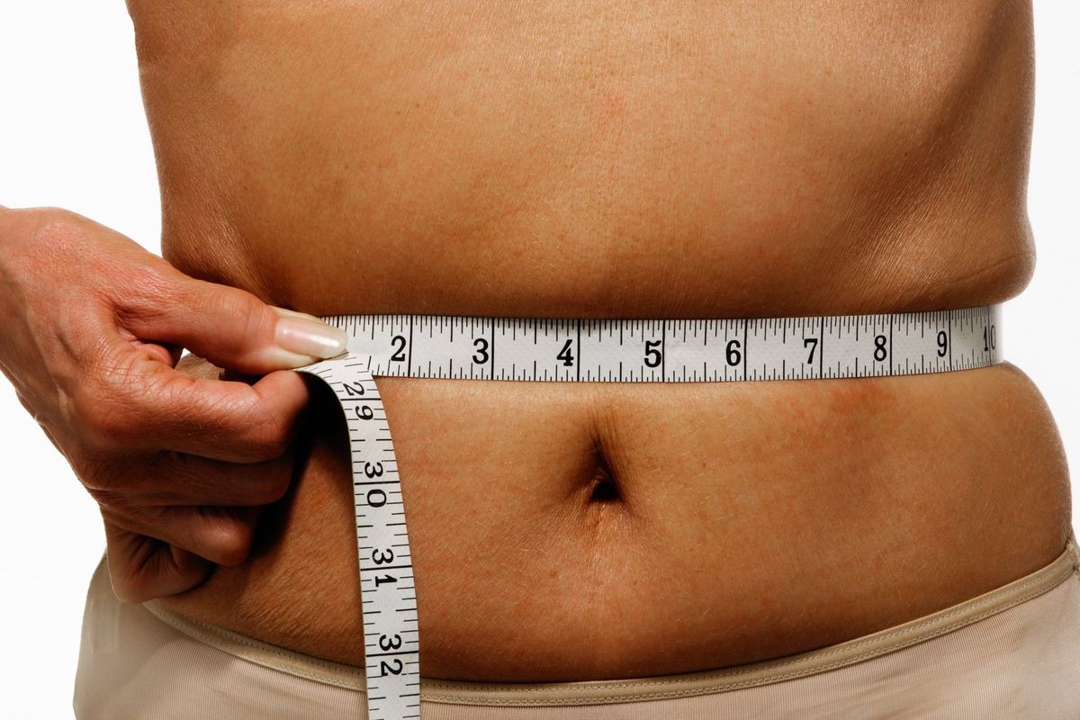 Woman measuring her waist