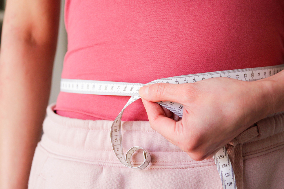 Woman measuring her waist