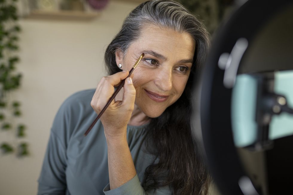 Woman pencilling in her eyebrows