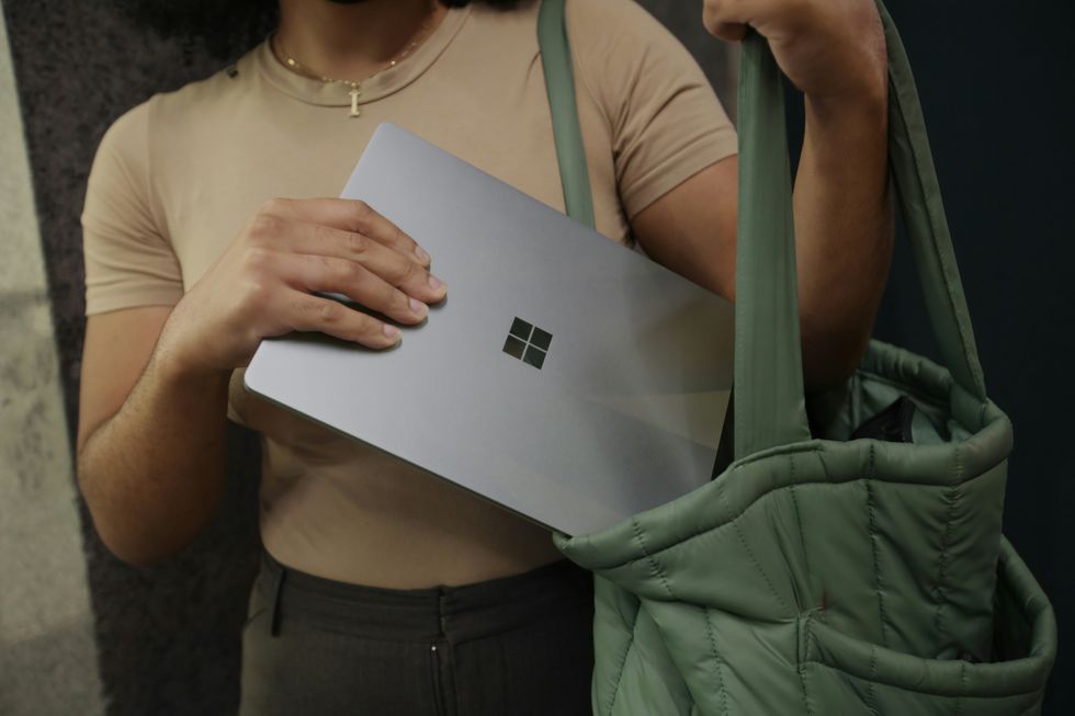 Woman placing laptop in bag