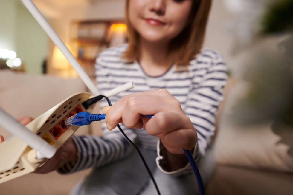 Woman plugging cable into router
