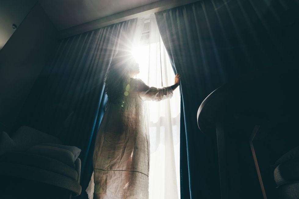 Woman pulling the curtains