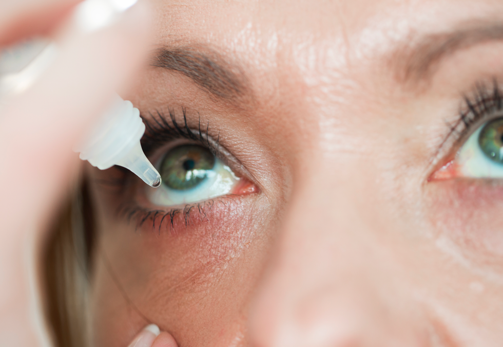 Woman putting eye drops in