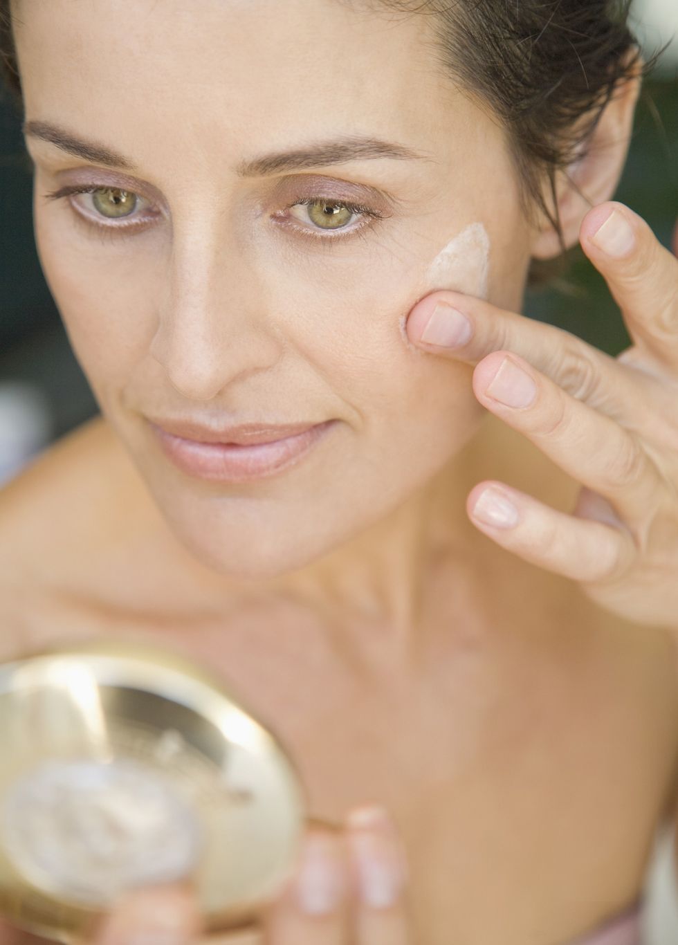 Woman putting on skin care