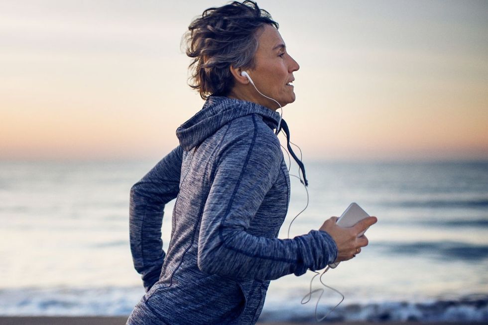 WOMAN RUNNING DOWN BEACH