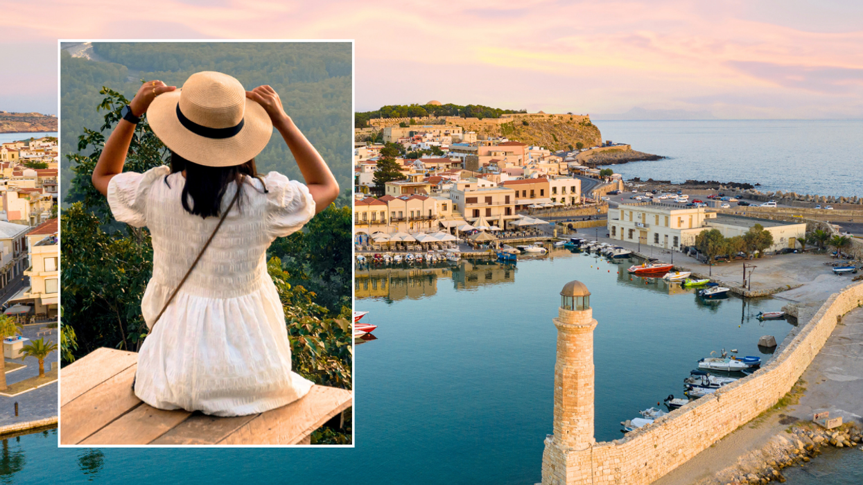 Woman sat holding hat / water in Crete