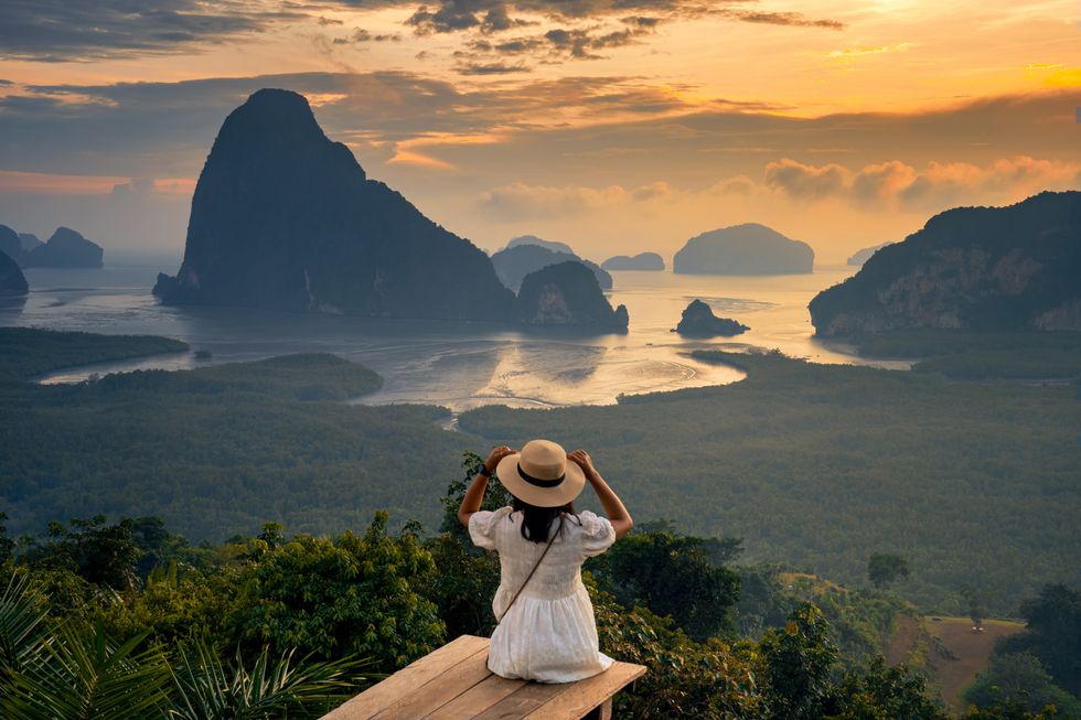 Woman sat in front of mountains in Thailand