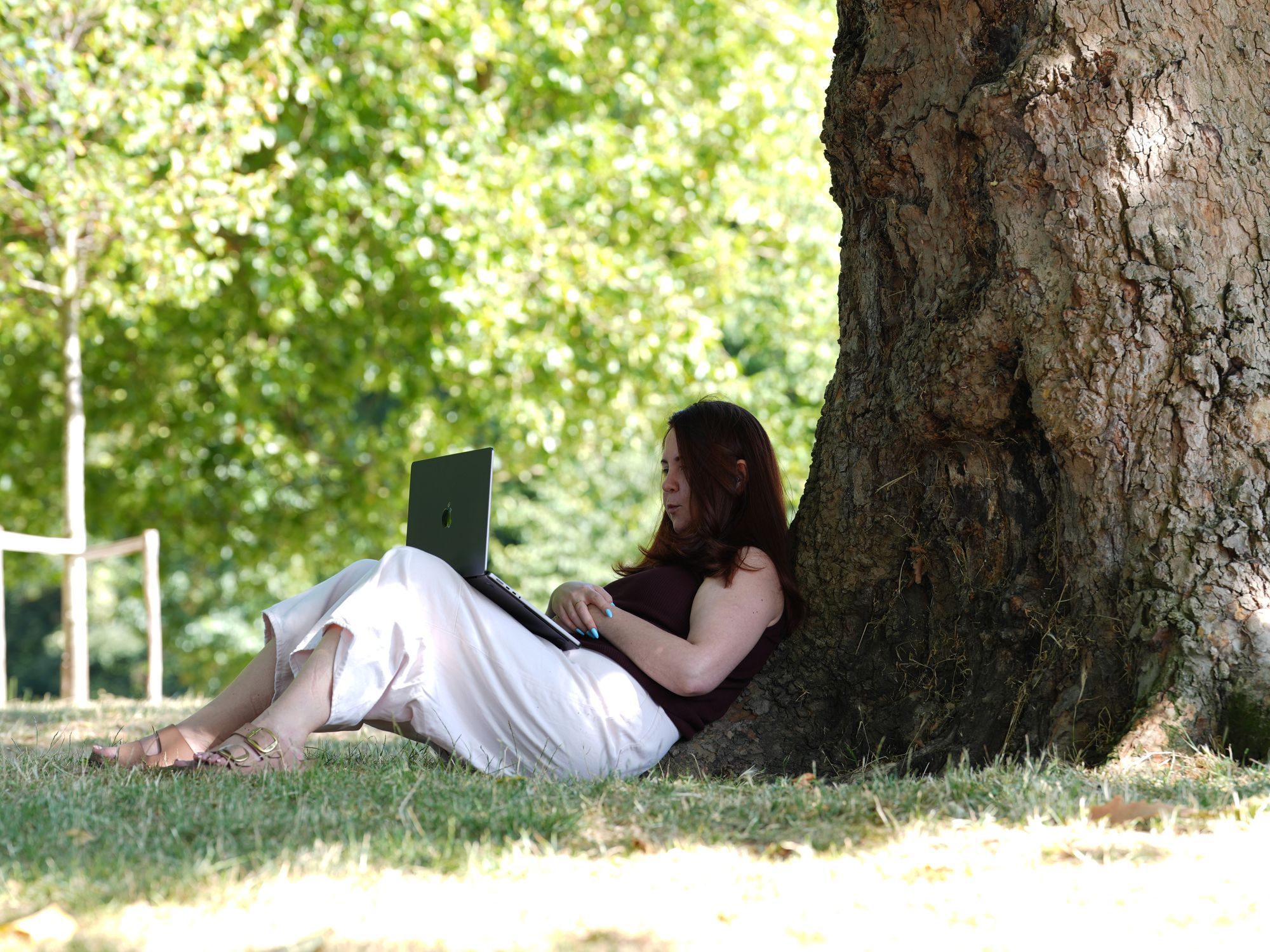 Woman sits under tree