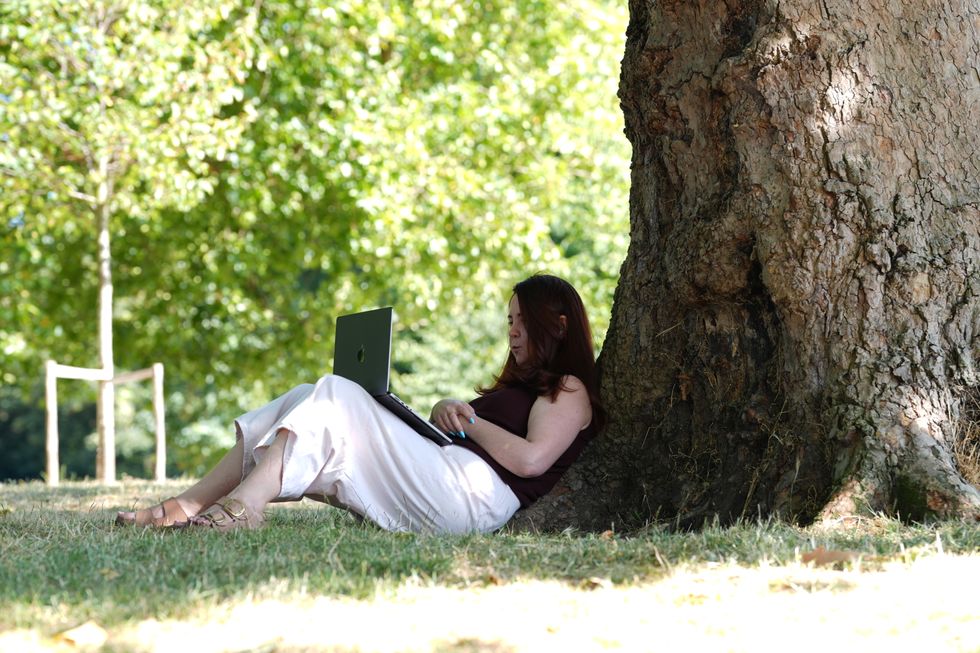 Woman sits under tree