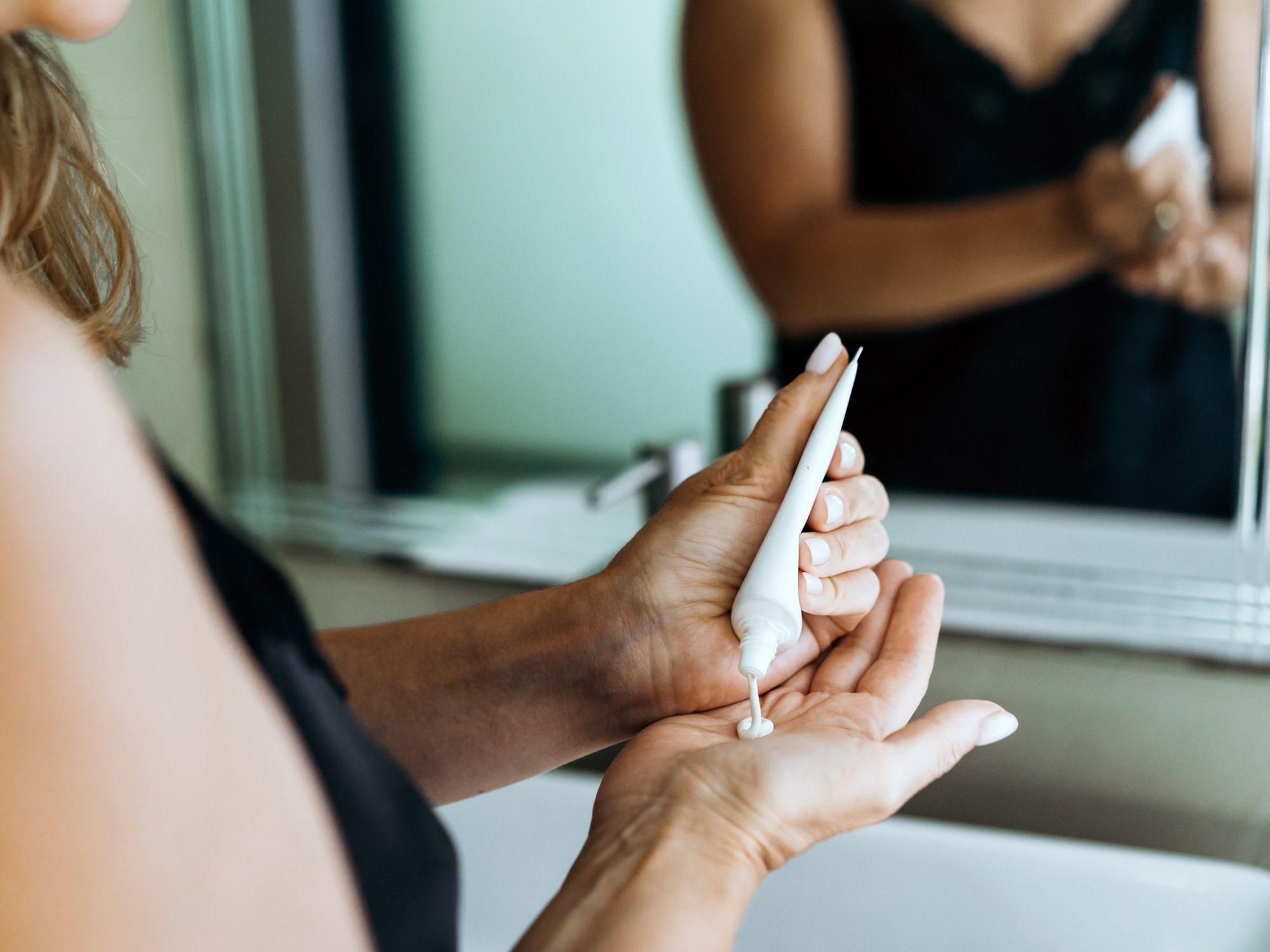 Woman squeezing skin care tube