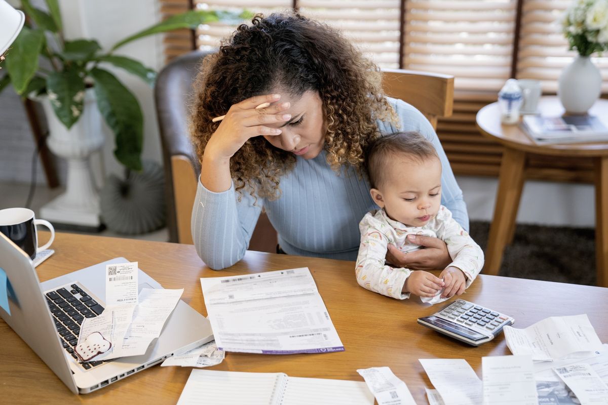 Woman stressed reading a document with her baby