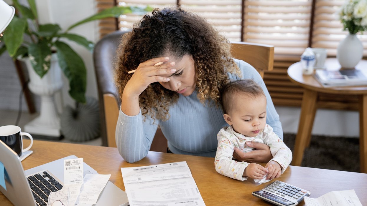 Woman stressed reading a document with her baby