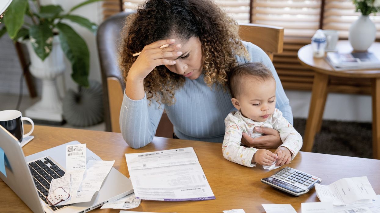 Woman stressed reading a document with her baby