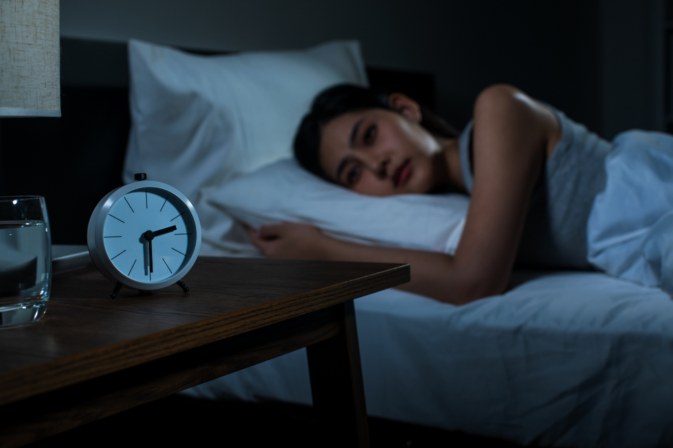 Woman struggling from insomnia, lying in bed