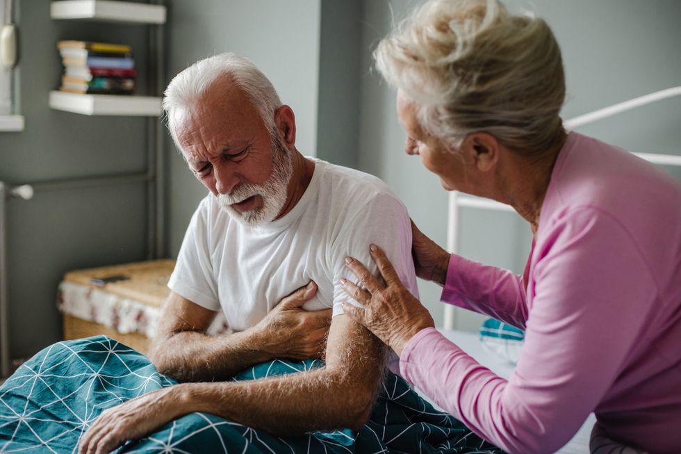 Woman supporting man with chest pain