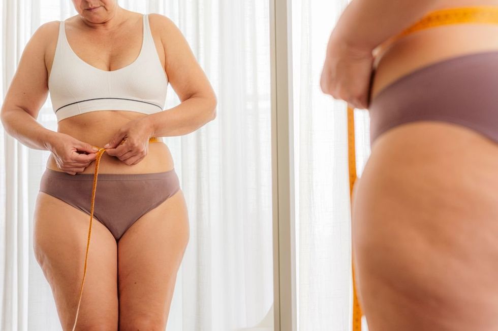 WOMAN TAKING WAIST MEASUREMENT