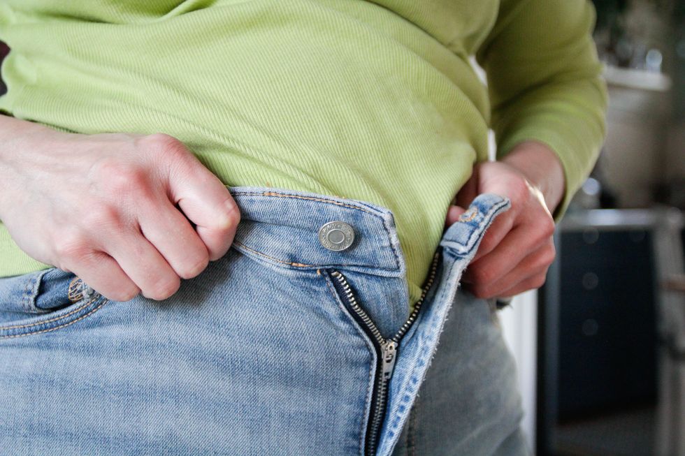 WOMAN TRYING TO CLOSE JEANS