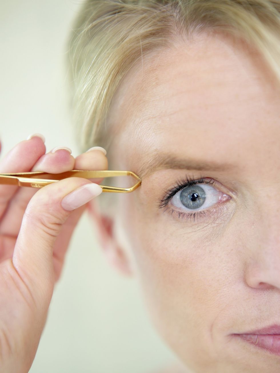 Woman tweezing her eyebrows