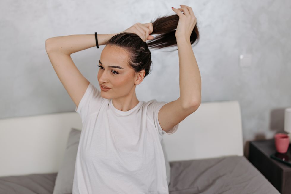 Woman tying her hair in ponytail