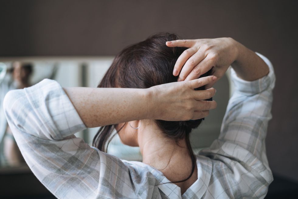 WOMAN TYING UP HAIR
