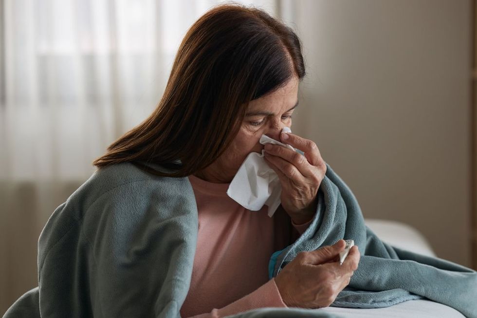 Woman unwell, blowing nose