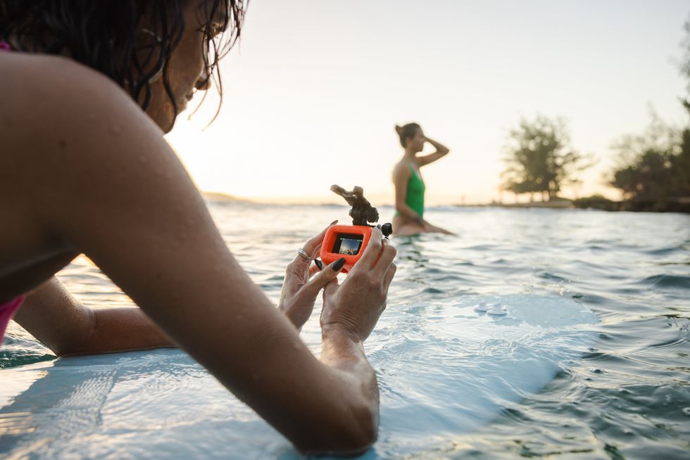 woman uses the gopro HERO in the water on a surfboard