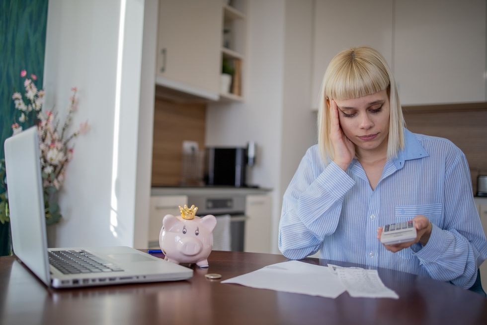 Woman using a calculator and looking worried