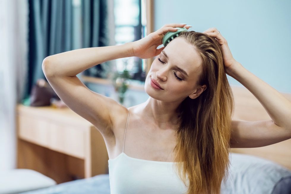 Woman using a scalp massager