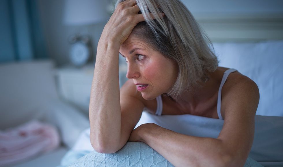 Woman waking up distressed in bed