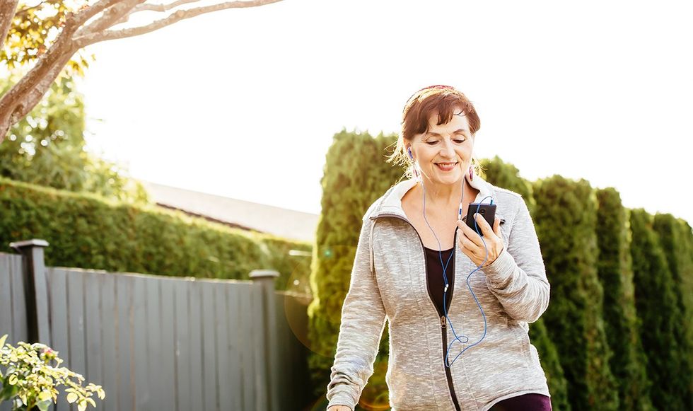 Woman walking and looking down at her phone