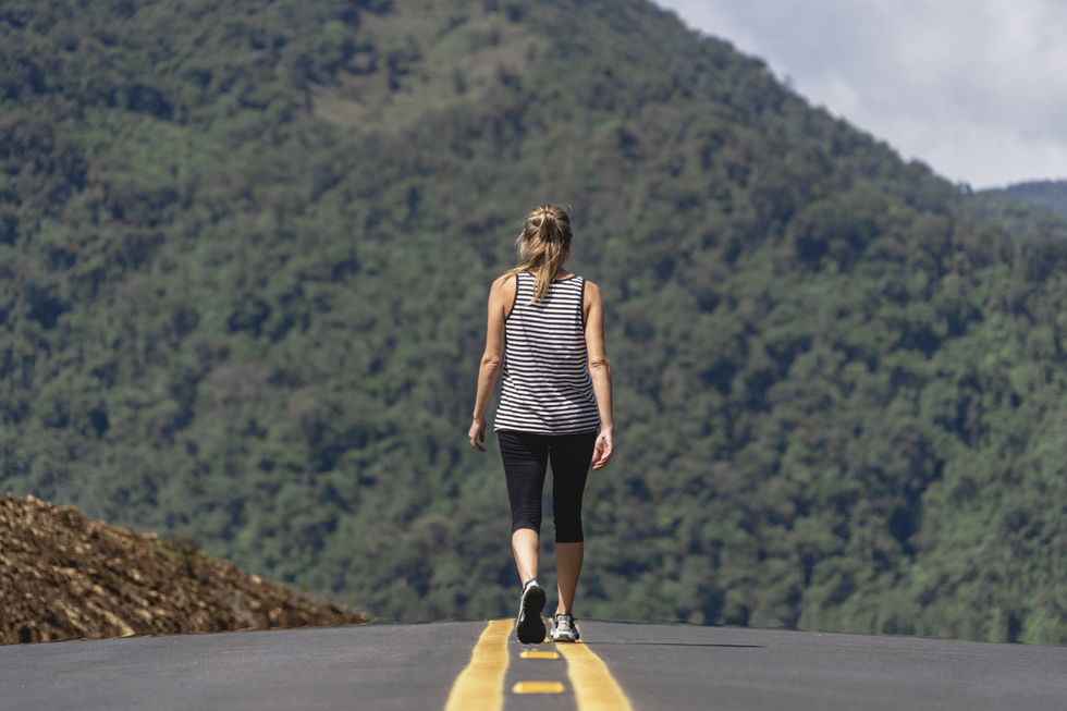 WOMAN WALKING DOWN THE ROAD
