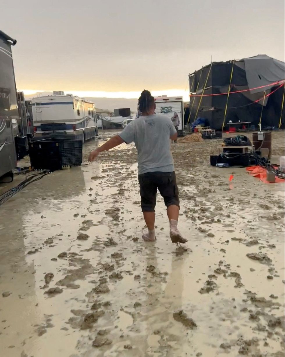 Woman walks in the mud at Burning Man 2023