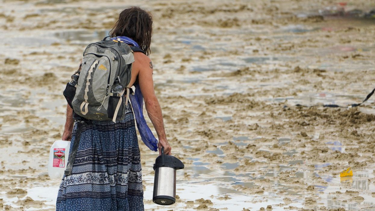 Woman walks in the mud at Burning Man festival
