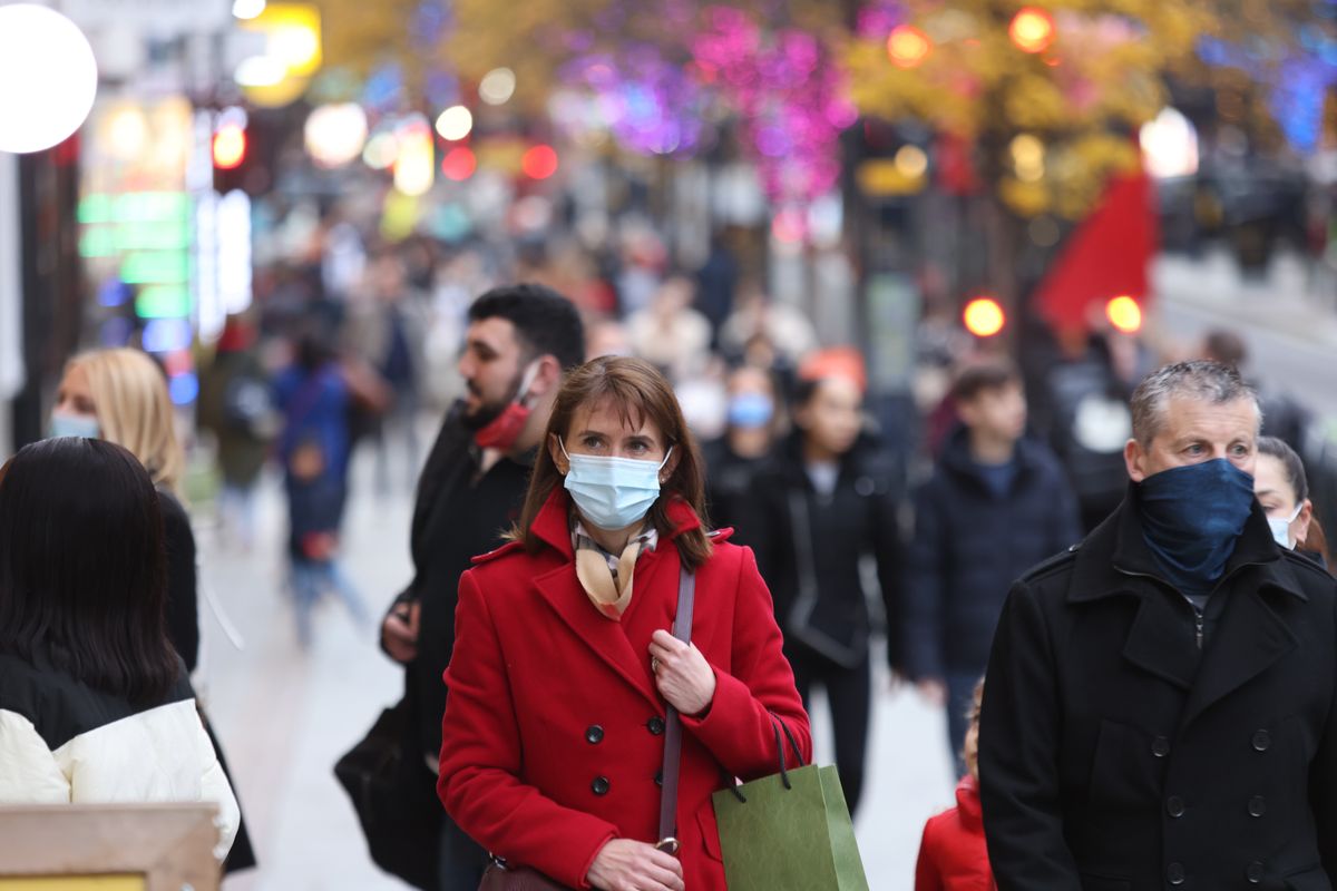 Woman wearing a mask walking through Oxford Street