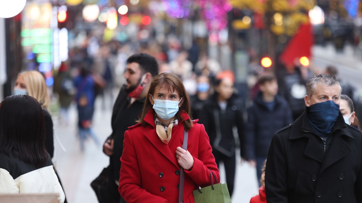 Woman wearing a mask walking through Oxford Street