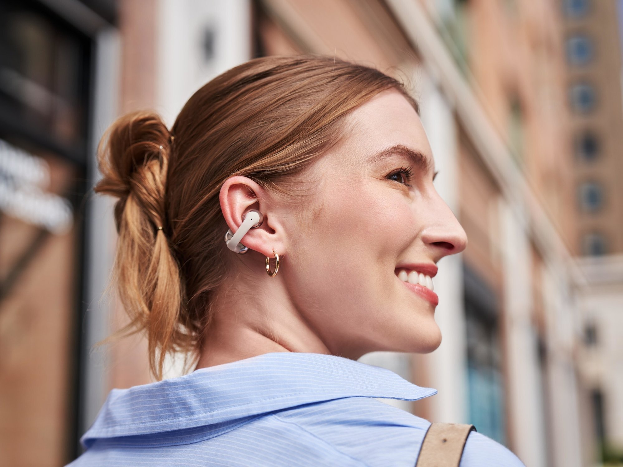 Woman wearing the OpenDots One earbuds from Shokz