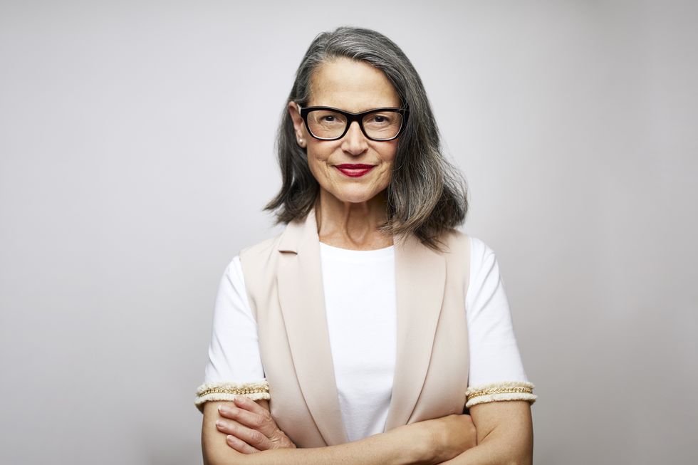 Woman with grey hair and glasses looking at camera