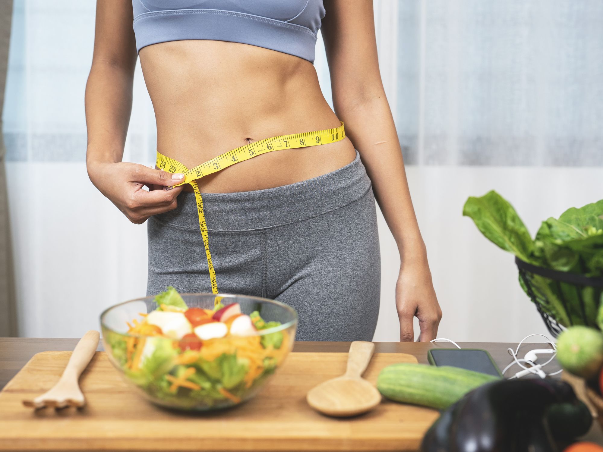 Woman with toned abs making healthy salad